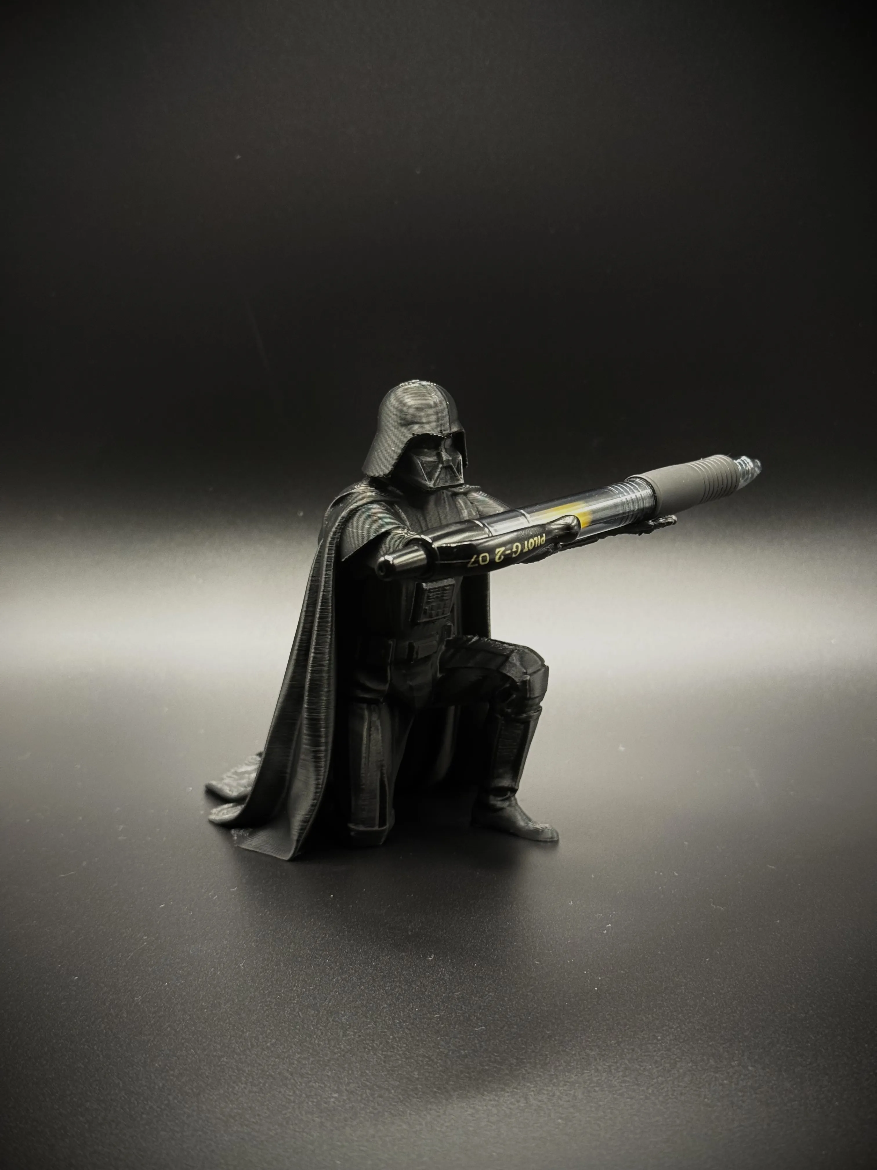 Kneeling Dark Lord pen holder in black, holding a pen across both hands