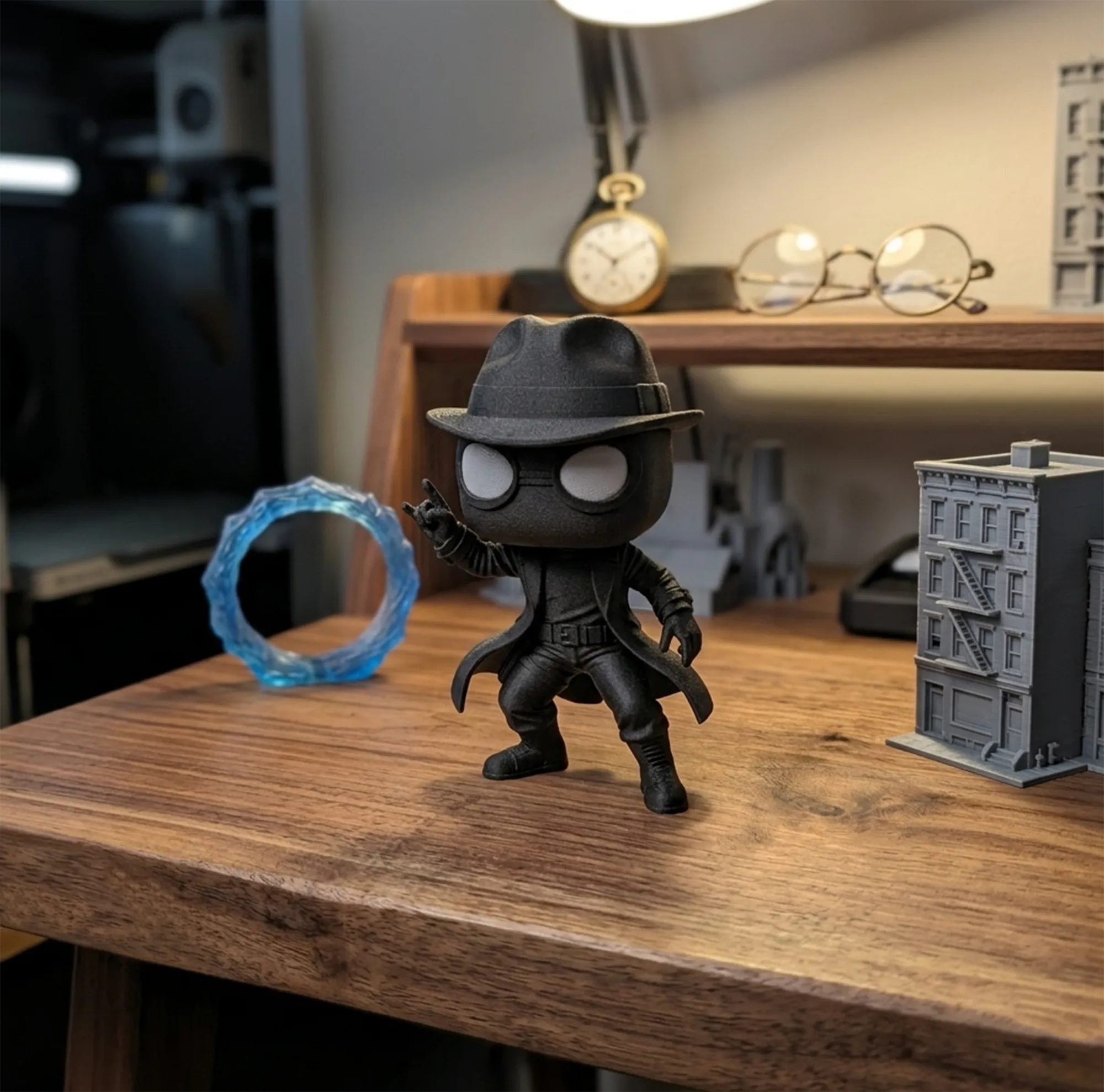A big-headed figure in a fedora and trench coat standing on a wooden desk