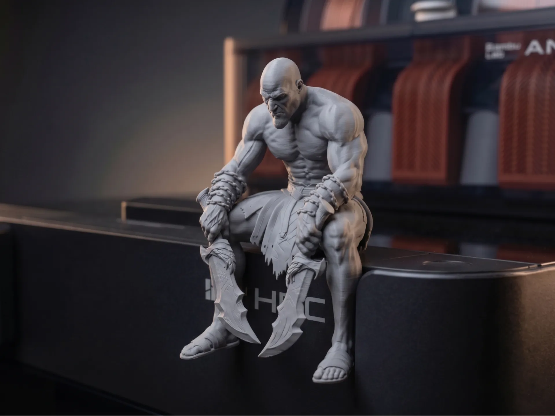 Bald warrior with chained blades, seated and looking down